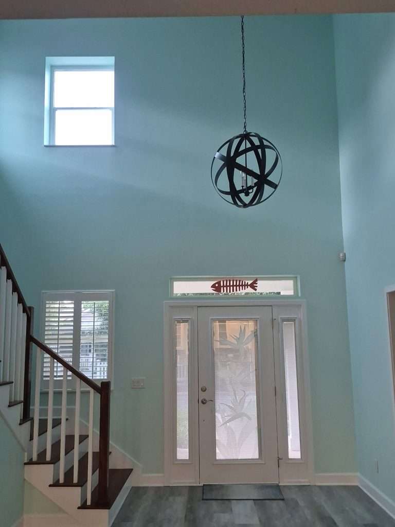 Two-story entryway with painted blue walls and staircase in a Palm Coast home