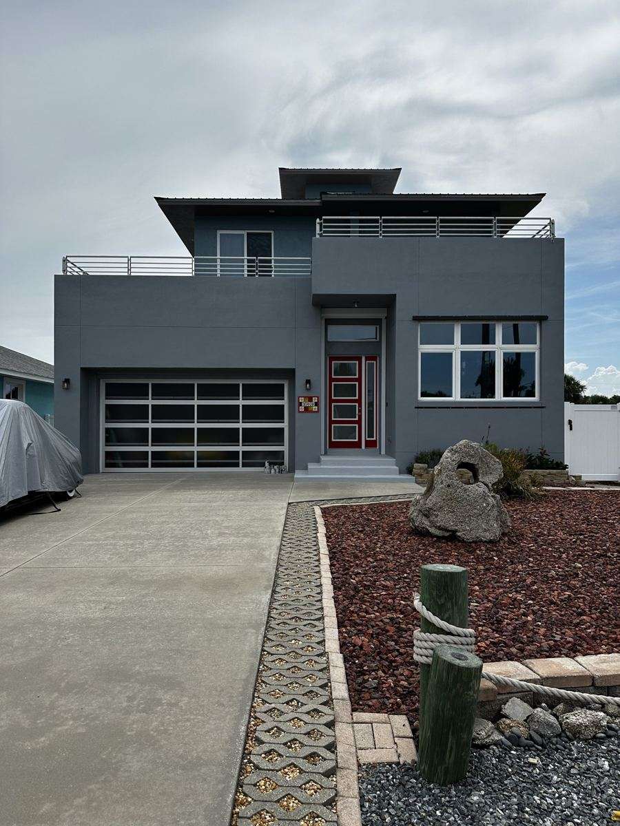 After: a gray exterior with white garage and railing details.