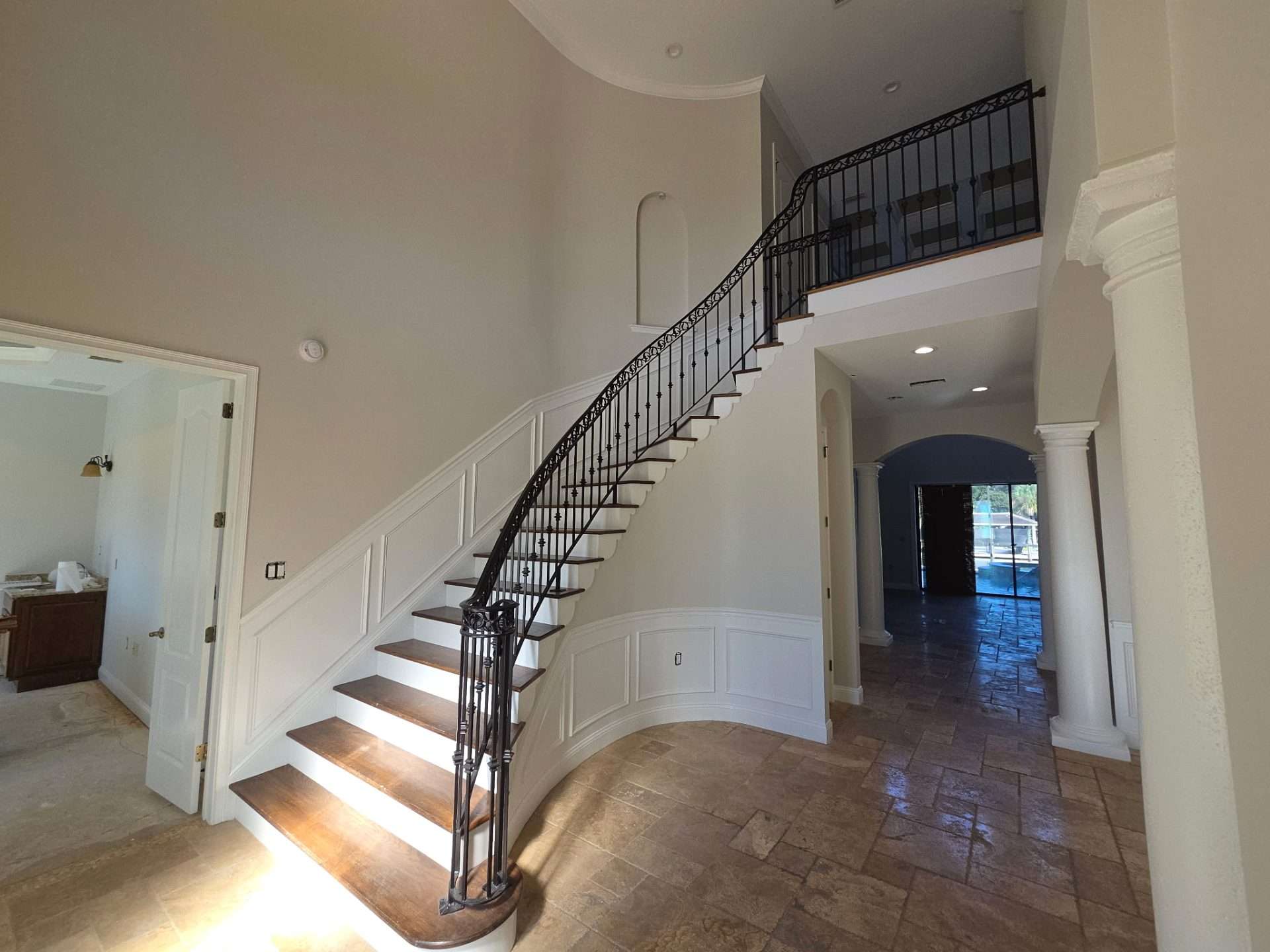Curved staircase with neutral walls and white architectural trim after interior painting in Palm Coast